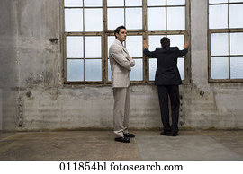 dos, hombres de negocios, posición, en, vacío, fábrica, edificio, uno, mirar, ot, de, ventana