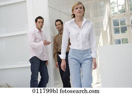 two talking behind the back of passing by woman two talking behind the back of passing by woman
