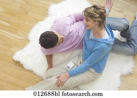 Paare, die auf dem Flüchten liegen und ein iPod teilen