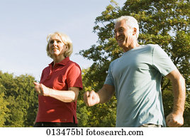 close-up of mature couple running through park close-up of mature couple running through park