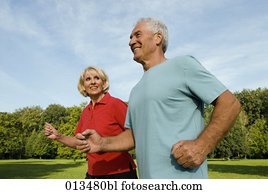 woman looking at man while running through park woman looking at man while running through park