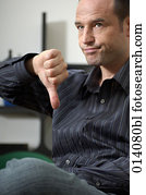 portrait of young man doing the thumbs down sign portrait of young man doing the thumbs down sign