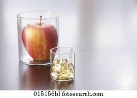 still life of apple and pills in jars still life of apple and pills in jars