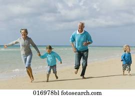 pareja madura, con, su, nietos, teniendo, un, caminata, por, el, playa