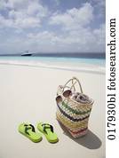 pair of flip flops and bag on sandy beach pair of flip flops and bag on sandy beach