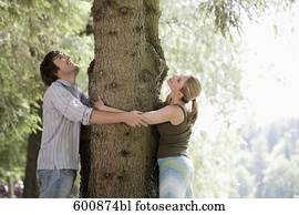 pareja joven, en el estacionamiento, se abrazar, árbol