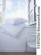 still life of white pillow and duvet on window sill still life of white pillow and duvet on window sill