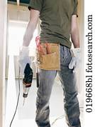 teilausschnitt, von, junger mann, mit, elektrische bohrmaschine, und, andere, bauwerkzeuge