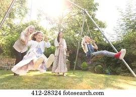 Carefree multi-generation women swinging in backyard