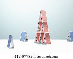 Contrasting, small houses of cards surrounding large house of cards