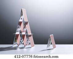 Small house of cards next to large house of cards