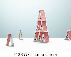 Small houses of cards surrounding large house of cards