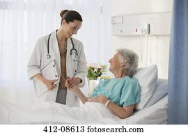 Doctor and senior patient talking in hospital room