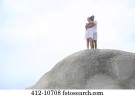 Couple hugging on rock formation