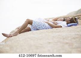 Couple relaxing on rock formation