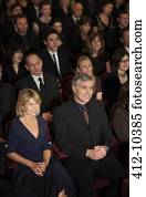 Smiling audience watching performance in theater