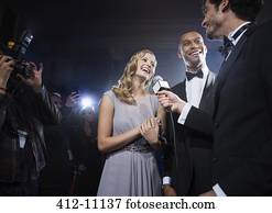 Well dressed celebrity couple being interviewed at red carpet event