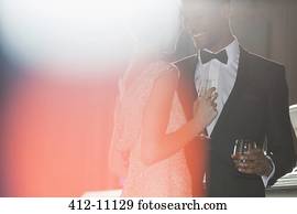 Well dressed couple drinking champagne and cocktail