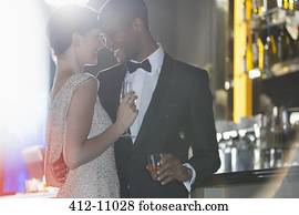 Well dressed couple hugging in luxury bar