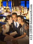 Well dressed friends hugging in luxury bar