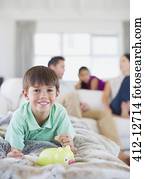 Boy counting change in piggy bank on sofa in living room Boy counting change in piggy bank on sofa in living room