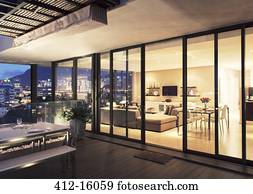 Illuminated modern living room and patio