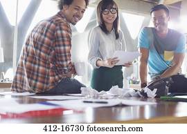 Portrait of happy creative business people with paperwork in meeting