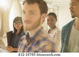 Portrait of smiling casual businesswoman with co-workers