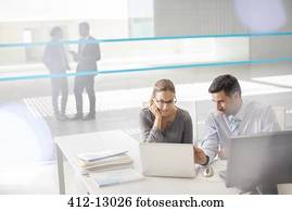 Business people working at laptop in office
