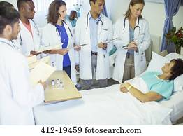 Doctor and residents examining patient in hospital