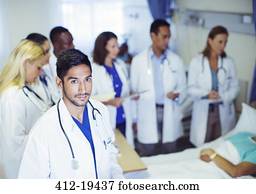 Doctor standing with residents in hospital room