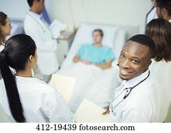 Doctor standing with residents in hospital room