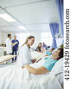 Doctor talking to patient in hospital room Doctor talking to patient in hospital room