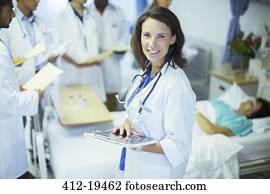 Doctor using digital tablet in hospital room