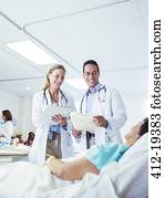 Doctors examining patient in hospital room