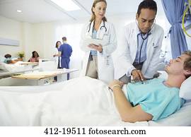 Doctors examining patient in hospital room