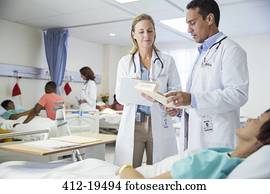 Doctors talking to patient in hospital room