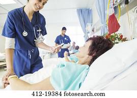 Nurse examining patient in hospital room