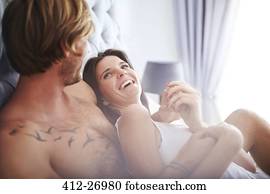 Casual couple cuddling on bed