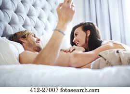 Casual couple laying on bed