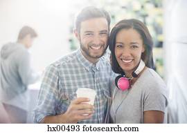 Portrait smiling creative business people with headphones and coffee