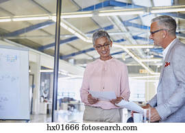Businessman and businesswoman discussing paperwork