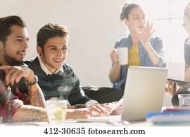 Creative young business people working at laptop