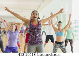 entusiástico, mulher, com, braços estendido, em, aeróbica, classe