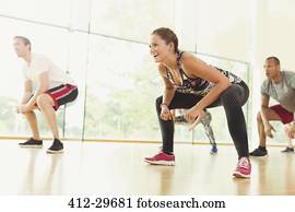 mulher sorridente, squatting, em, aeróbica, classe