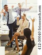 Playful business people throwing paper airplanes at each other in office