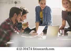 Young creative business people working at laptop