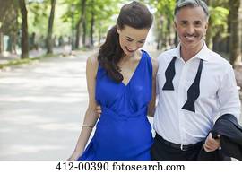 Smiling well-dressed couple in park