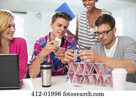 Business people making house of cards in office