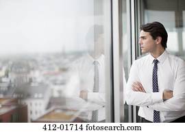 Businessman looking out office window
